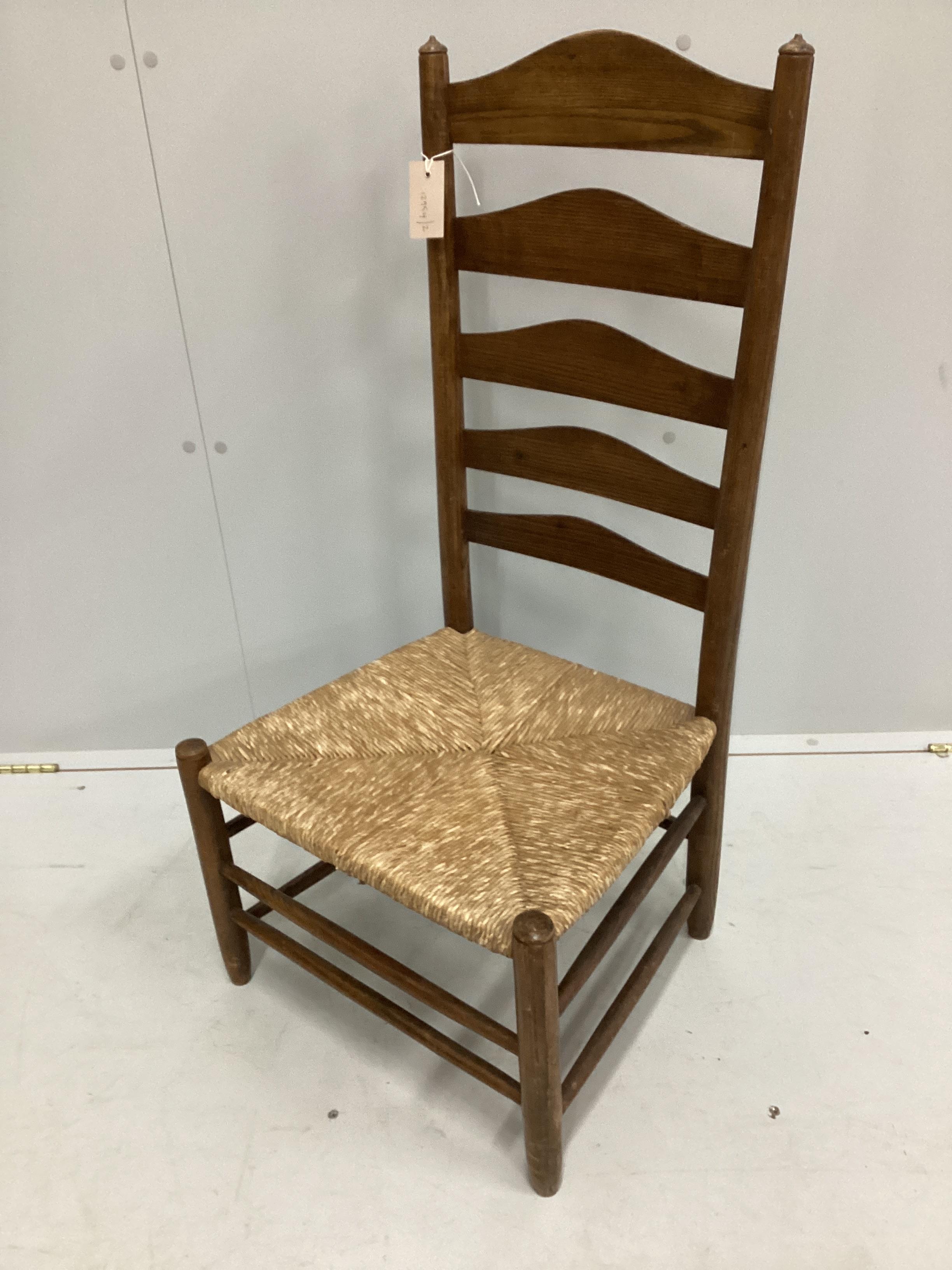 An early 20th century Arts and Crafts ash rush seat ladderback nursing chair possibly by Edward Gardner, width 46cm, depth 40cm, height 93cm